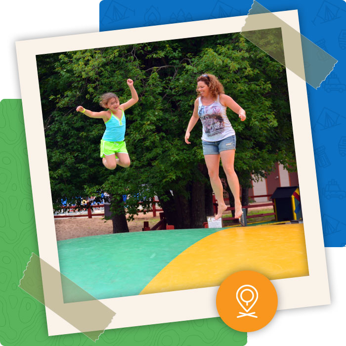 Mom and daughter bounce on the jumping pillow feature at Pineland family friendly Camping Park in Big Flats WI